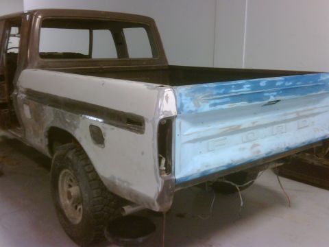 1979 Ford F-250 - This pickup truck's rear end is undergoing bodywork, with primer and blue paint visible on the tailgate.