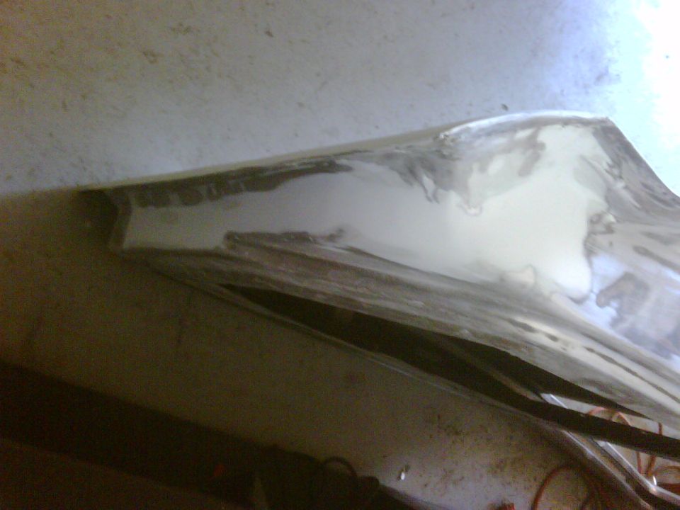 Body panel with Bondo filler and primer, showing repair work