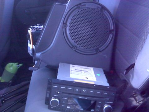 2008 Jeep Wrangler - Aftermarket car stereo and speaker enclosure are placed on the vehicle's seat, ready for installation.