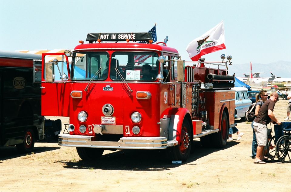 Red fire truck with 'NOT IN SERVICE' sign on top, California flag flying