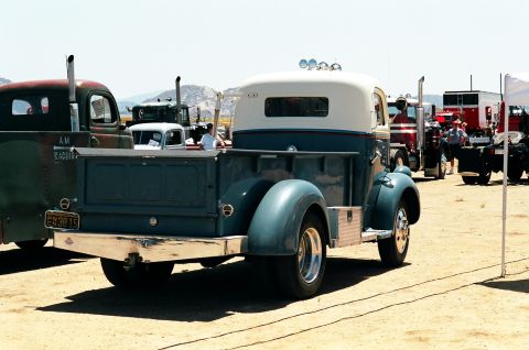 1981 Kenworth W900A - A classic pickup truck is parked at an outdoor event with other large vehicles in the background.