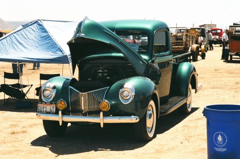 1981 Kenworth W900A - A vintage green Ford pickup truck is displayed with its hood open at an outdoor event.