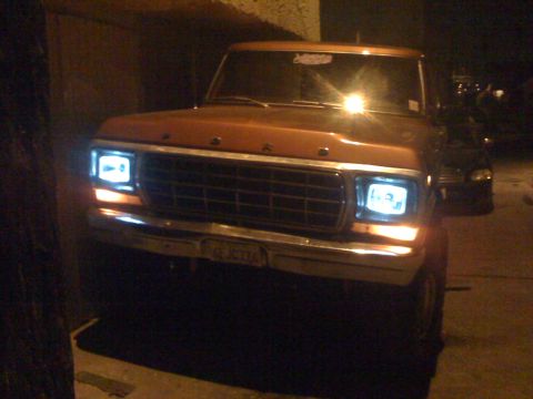 1978 Ford Bronco - Front view of a 1978 Ford Bronco parked at night with headlights illuminated.
