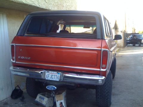 1978 Ford Bronco - Orange 1978 Ford Bronco seen from the rear, a black top and lifted suspension.