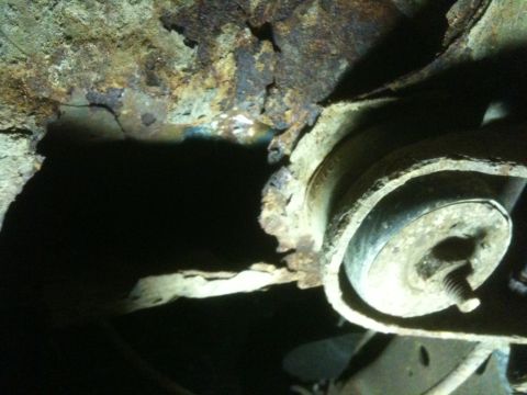 1993 Ford Bronco - Close-up view of severe rust and corrosion on a vehicle's undercarriage components.