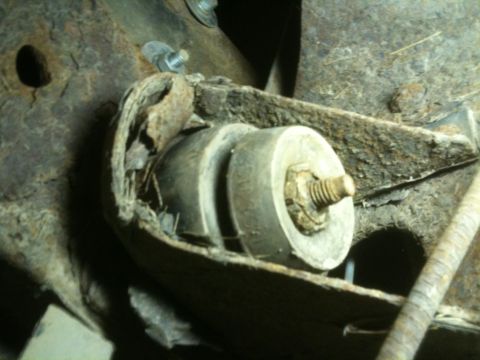 1993 Ford Bronco - Close-up of a worn suspension bushing, showing significant rust and damage to surrounding metal components.