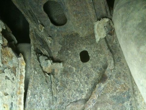 1993 Ford Bronco - Detail of a corroded vehicle frame structure, showing a bolt and mounting points.