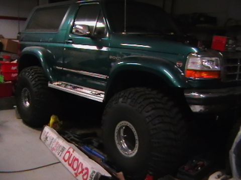 1996 Ford Bronco - This lifted Ford Bronco is shown from the front three-quarter view, with its large off-road tires visible.