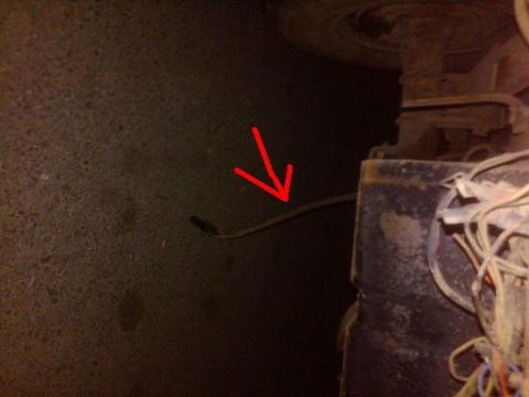 1982 Ford Bronco - A red arrow points to a wiring harness visible on the underside of a vehicle.