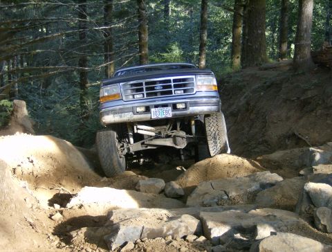 1996 Ford Bronco - This 1995 Ford Bronco tackles a challenging off-road course with its front wheels climbing over large rocks.