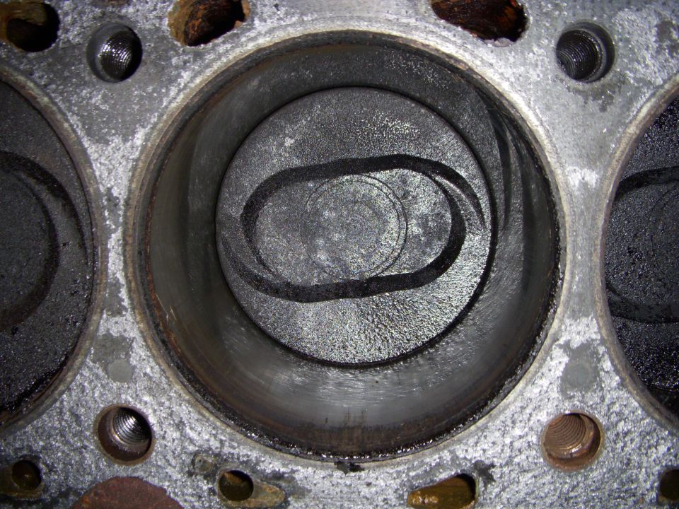 Close-up of an engine cylinder with carbon buildup and visible valve seats