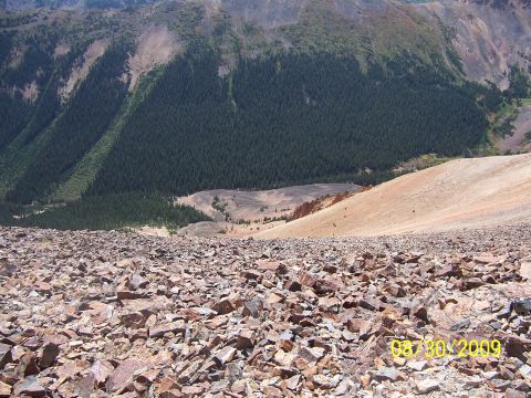 1994 Ford Bronco - A view down a rocky mountain slope towards a forested valley, with a date stamp visible in the lower right corner.