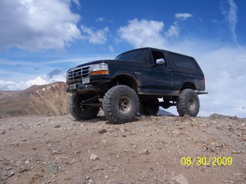 1994 Ford Bronco - This lifted 1994 Ford Bronco is shown off-road on a rocky mountain landscape.