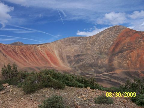 1994 Ford Bronco - Mountain landscape with red rock formations and sparse vegetation under a blue sky.