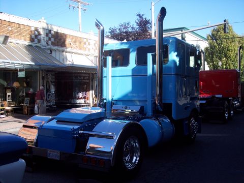 1981 Kenworth W900A - Blue 1981 Kenworth W900A semi-truck with chrome stacks, parked next to a red trailer.