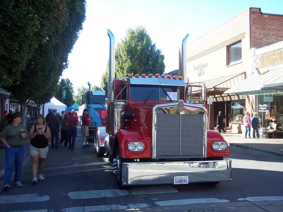 Red 1981 Kenworth W900A semi-truck with chrome grille and bumper, parked on a street