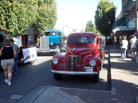 1981 Kenworth W900A - Two vintage trucks parked on a street during a sunny day event.