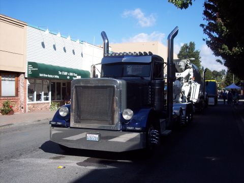 1981 Kenworth W900A - A 1981 Kenworth W900A truck is parked on a street next to a cement mixer truck.