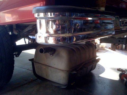 1989 Ford Bronco - Fuel tank installation or removal process shown from underneath a vehicle.