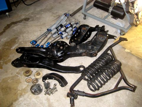 1996 Ford Bronco - Various automotive suspension parts are displayed on a workshop floor.