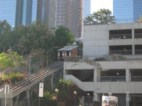 1986 Ford Bronco - A funicular railway with two cars is seen ascending a hill, surrounded by urban architecture.