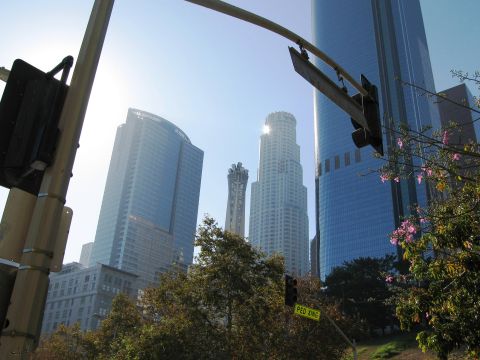 1986 Ford Bronco - Cityscape with skyscrapers and traffic signals under a bright sun.