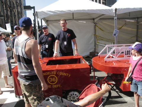 1986 Ford Bronco - A group of people observe a custom-built soap box derby car designed to resemble a fire department vehicle.