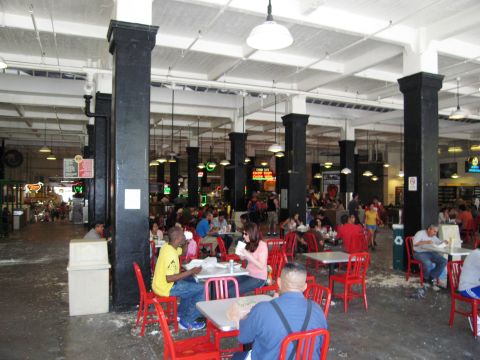 1986 Ford Bronco - A bustling indoor market scene with patrons seated at tables, enjoying their meals amidst the lively atmosphere.