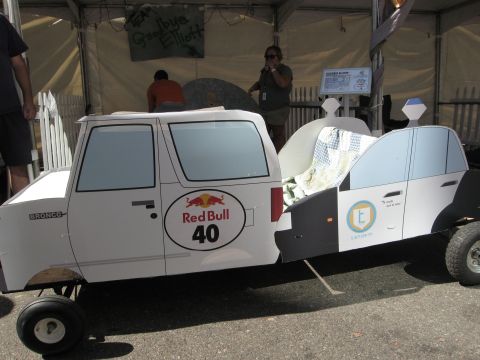 1986 Ford Bronco - A custom-built soapbox derby car designed to look like a Ford Bronco and a police car is displayed outdoors.
