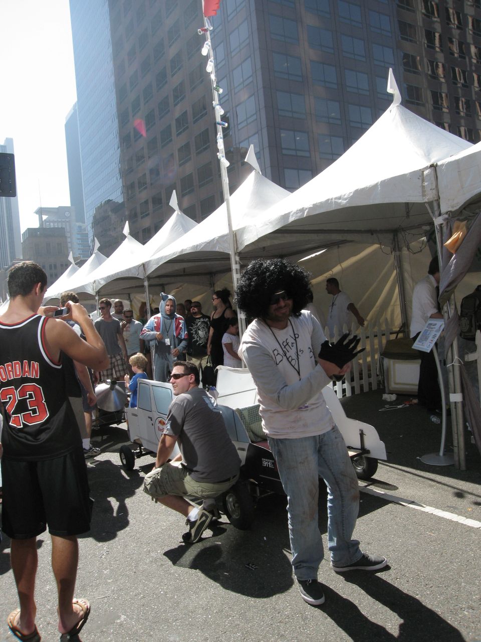 People gathered around tents at an outdoor event, with some individuals in costumes