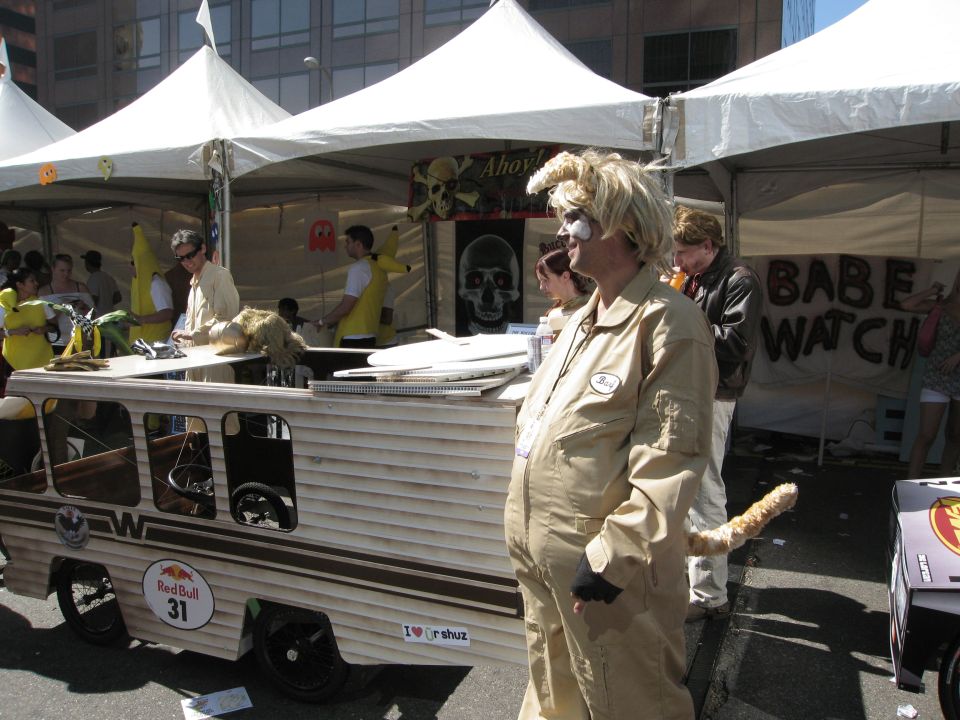 Custom van-like vehicle with Red Bull 31 logo, people in banana costumes, and a person in a tan jumpsuit with a tail
