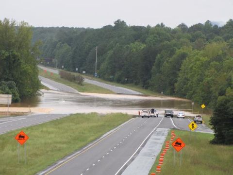 1979 Ford F-150 - A flooded highway scene with multiple vehicles halted due to high water.