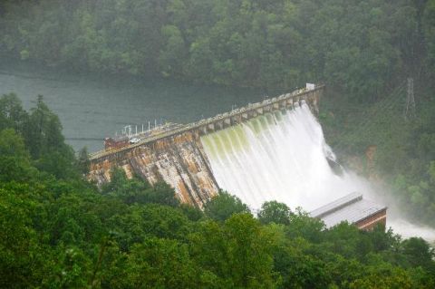 1979 Ford F-150 - Water flows over a large dam, with a single car positioned on the walkway above.