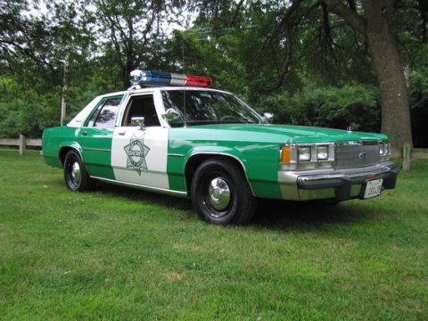 2001 Ford Crown Victoria - This vintage Sheriff's patrol car features a distinctive green and white paint scheme and a light bar.