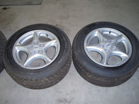 2002 Chevrolet Camaro - A pair of aftermarket alloy wheels with tires are displayed on a concrete surface.