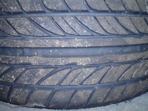2002 Chevrolet Camaro - A close-up view of a worn tire tread shows dirt accumulation and minor cracks.