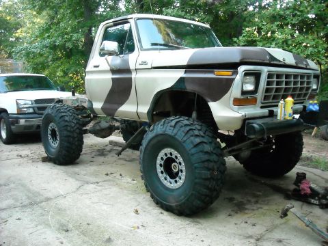 1979 Ford F-150 - Modified 1979 Ford F-150 pickup truck with custom paint and suspension, alongside another truck.