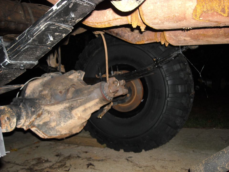 Rear axle assembly and leaf springs of a vehicle, showing rust on exhaust components