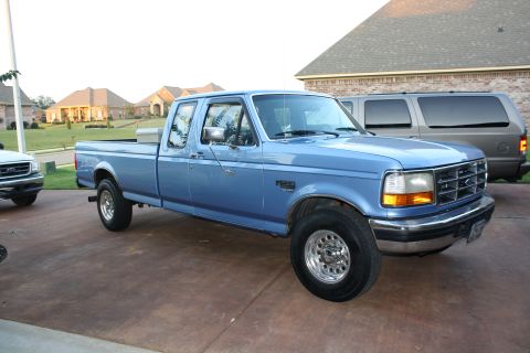 1995 Ford Bronco - This blue pickup truck, likely a mid-1990s Ford F-Series, is shown from a three-quarter front perspective.