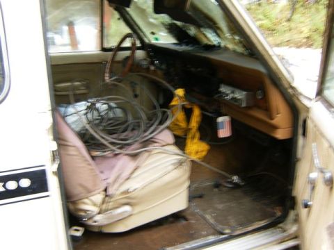 2000 Ford E350 - The interior of a van shows a passenger seat covered in a coiled cable and an American flag air freshener hanging from the dashboard.