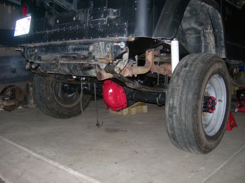 1991 Jeep Wrangler - The rear axle of a black Jeep Wrangler shows a red differential cover and large tires.