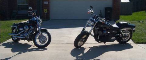 1996 Ford Bronco - Two motorcycles are parked on a concrete driveway in front of a residential garage.