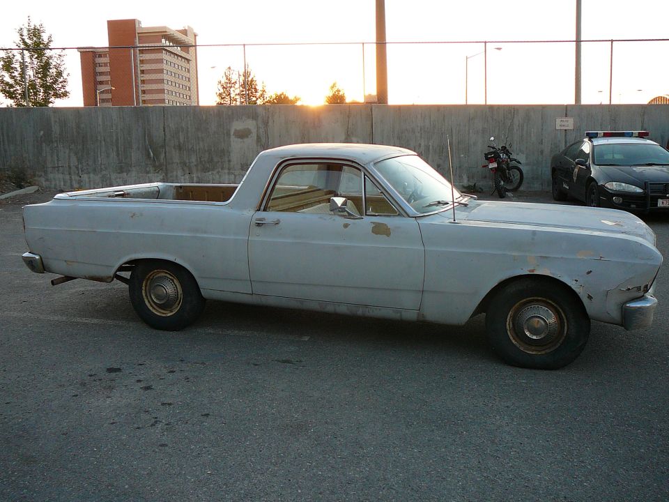 Light blue 1966 Ford Ranchero pickup truck, side view, showing faded paint and some rust spots