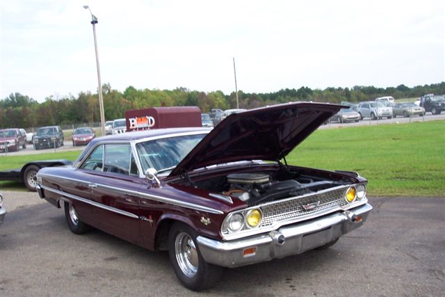 Maroon coupe with hood open, showing the engine. Chrome trim and wheels