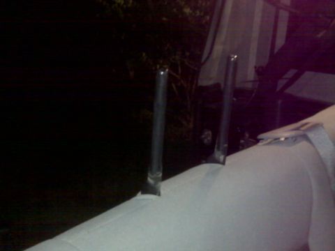 2008 Jeep Wrangler - Two metal headrest posts are visible protruding from a white seat cover.