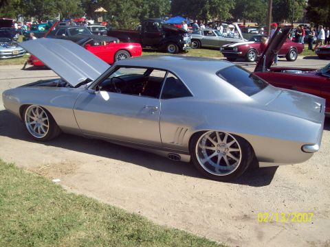 1995 Ford Probe - A silver 1969 Chevrolet Camaro is displayed with its hood open, custom wheels and a lowered stance.