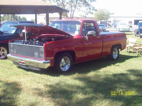 1995 Ford Probe - A red pickup truck is parked on grass with its hood open, showing the engine bay.