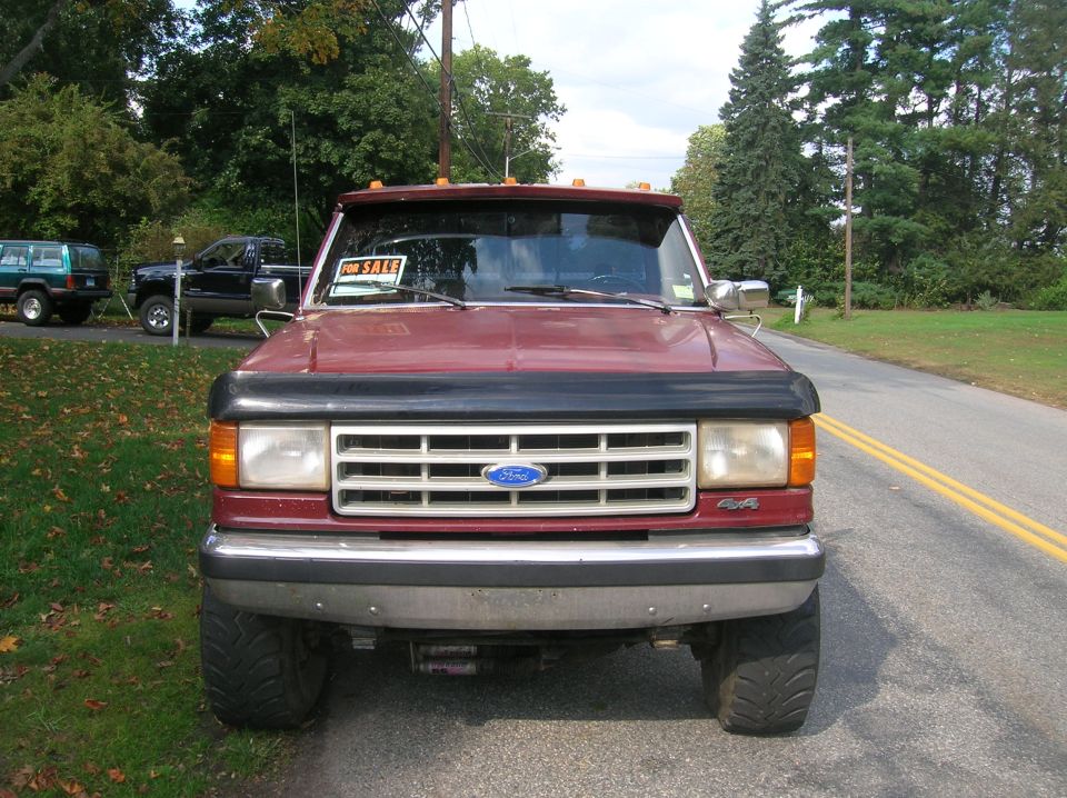 Maroon 1989 Ford F-350 pickup truck front view with 'For Sale' sign in window