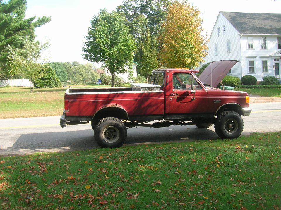 1989 Ford F-350 pickup truck parked on the side of the road, hood is open