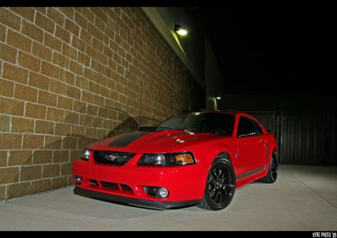 2004 Ford Mustang - This red Mustang is parked outside at night with a black stripe on the hood.
